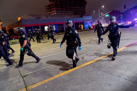 Oakland Police Department officers follow the 'Justice for Jacob' protest down Harrison Street in Oakland, Calif., August 26, 2020. Shortly after police declared the protest an unlawful assembly and gave people five minutes to disperse.