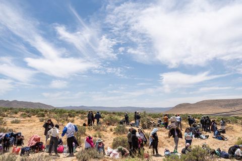 people sitting and standing around in the desert