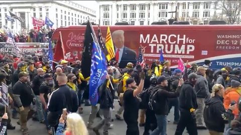 A video uploaded to the defunct social media website Parler shows the Proud Boys marching beside a red “Woman for America First” bus in Washington, D.C. on December, 12, 2020.
