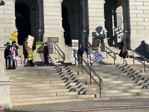 WBC stands on top of the Colorado state capital steps carrying various signs with antisemitic and homophobic messages