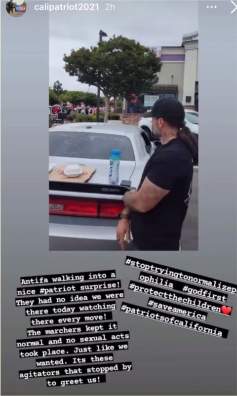 instagram post of forzano looking out over the crowd of marchers with a pizza on the hood of a car. caption says "antifa walking into a nice patriot surprise! they had no idea we were there today watching their every move! the marchers kept it normal and no sexual acts took place. just like we wanted. it's these agitators that stopped by to greet us!"
