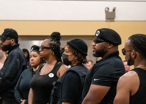 Members of the Black Panther Party of San Diego stand and look to the left of the frame, all of them in various articles of black clothing.