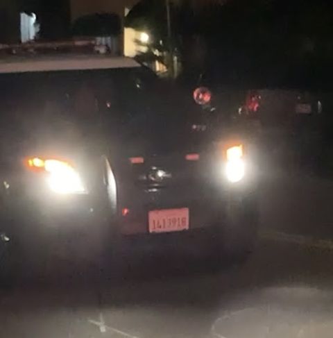 partial view of the front of a police cruiser, the license plate is the same as the one Devor was driving above. It is night, the headlights are on