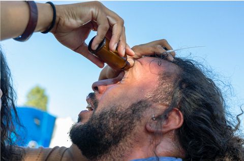 Protester washes mace from his eyes with help from a street medic.