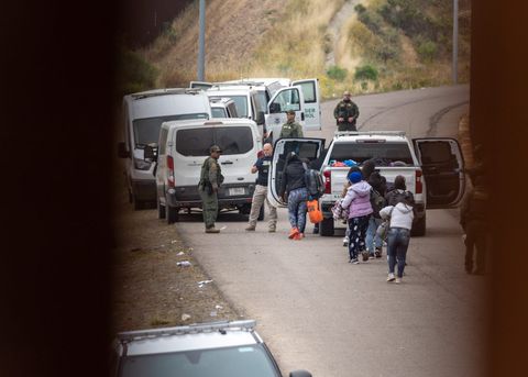 people loading into a border patrol van