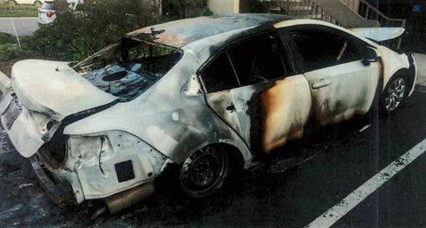 A burned out Camry in an apartment complex's parking lot.
