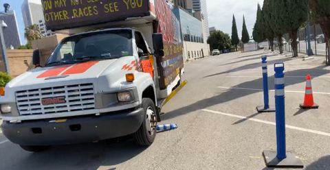 the GDL's banner-covered u haul truck parked in a parking lot across several spaces