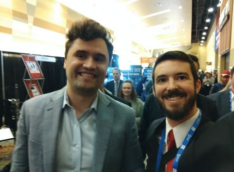 In media row at AmericaFest, Charlie Kirk smiles and takes a photo with white nationalist Greyson Arnold