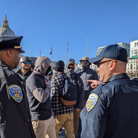 officers conversing with and pointed at masked nazis in a crowded downtown San Francisco