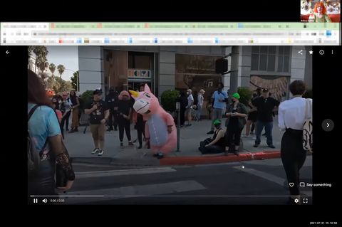 Belissa Cohen, top right, giving a presentation. A person in a pink unicorn costume is dancing while pro-trans protesters watch