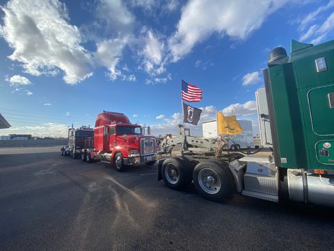big trucks in a parking lot with don't tread on me flags