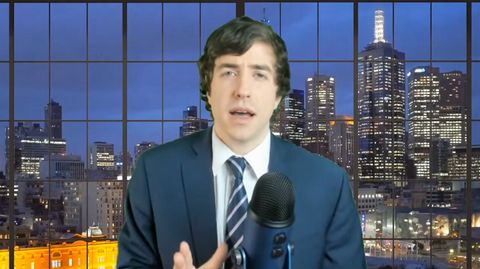 Patrick Casey on his Why I'm Not Going to AFPAC stream. He wears a suit and has a green screen 