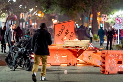 A roadblock made from construction barriers, signs, and pallets burns at Broadway Avenue and 21st Street as protesters calling for 'Justice for Jacob' march through the streets of Oakland, Calif., August 26, 2020. Jacob Blake was shot seven times in the back by police in Kenosha, Wis. — his shooting has reignited Black Lives Matter protests.