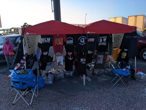 A merchandise tent draped with qanon and other tshirts