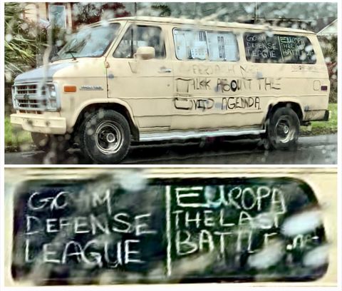 The van described above as seen through a rain-covered window with details of the windows that say 'Goyim Defense League' and 'Europa the last battle'