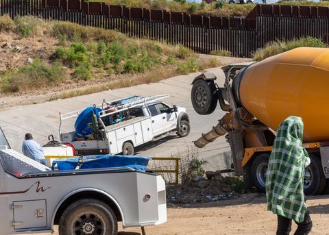 construction vehicles including a cement truck near the border fence