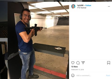 Roman smiling and posing with a rifle at a shooting range.