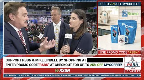 Christina Bobb and RSBN host Brian Glenn listen to Mike Lindell as he rambles on. RSBN is wrapped with an ad for My Coffee, Lindell’s new product. The ad shows two blue coffee bags and a coffee cup with Mike Lindell holding a flag. The bottom chyron reads “a federal judge will hear evidence against the use of electronic voting machines in Arizona.”