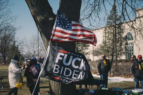 people standing around a flag that says 'fuck joe biden'