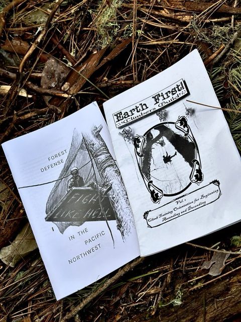 pamphlets on the forest floor that read "earth first climb guide" and "forest defense in the pacific northwest"