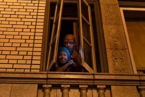 30-year residents of Adams Point pose for a photo in the window of the apartment during the 'Justice for Jacob' protest in Oakland, Calif., August 26, 2020. The couple said they were unable to sleep due to noise as protesters were dispersed by police.