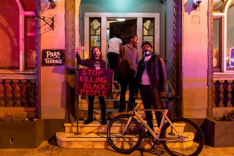 Residents of Adams Point stand outside their apartment as police disperse protesters at the 'Justice for Jacob' protest in Oakland, Calif., August 26, 2020.