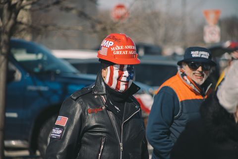 a man in facepaint wearing a safety helmet smiles